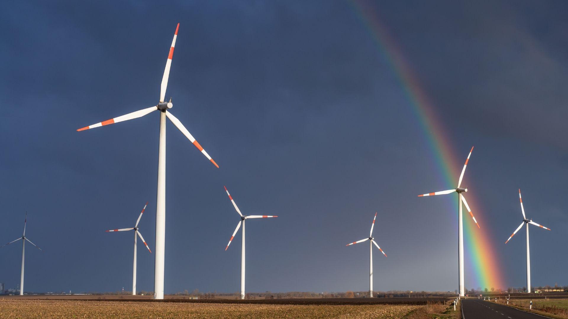 Wind farm after a storm with a rainbow.