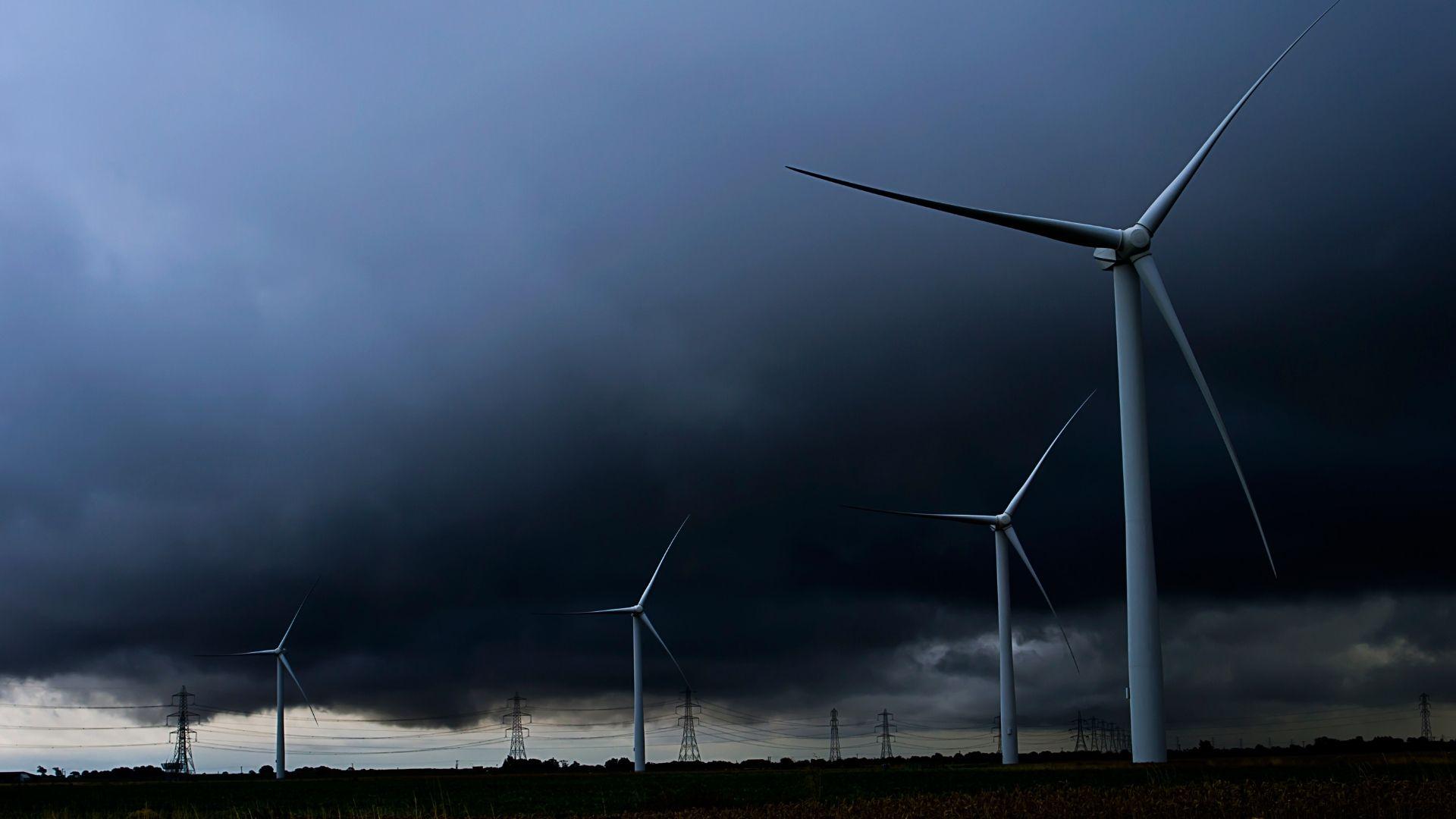 Four wind turbines and a black sky.