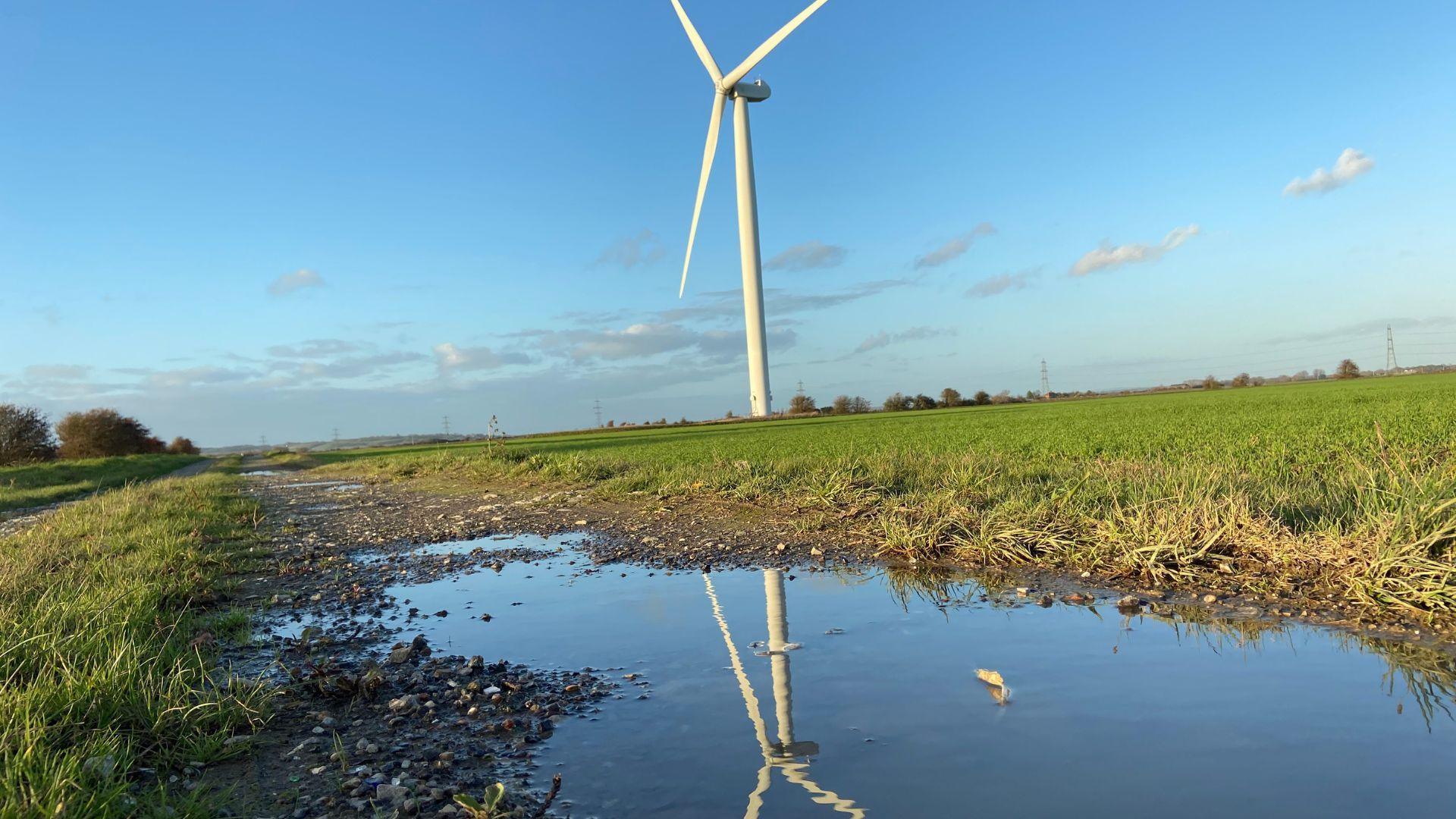 Wind turbine with reflection in the water.